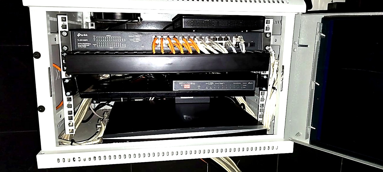 After: the same cabling terminated into a wall-mounted rack, with the PoE switch and recorder mounted and the runs dressed to the side.