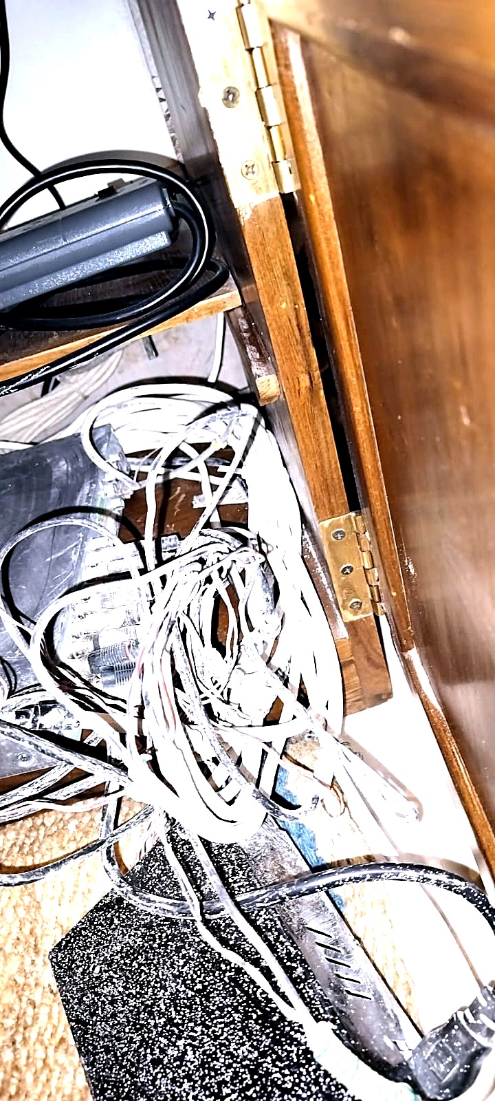 Before: loose network and power cabling tangled in the base of a wooden cabinet at a private residence in Mumbai.
